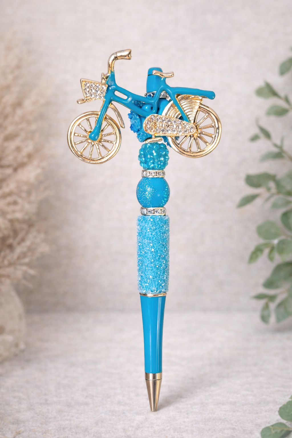 Blue bicycle-charm bling pen on a neutral background