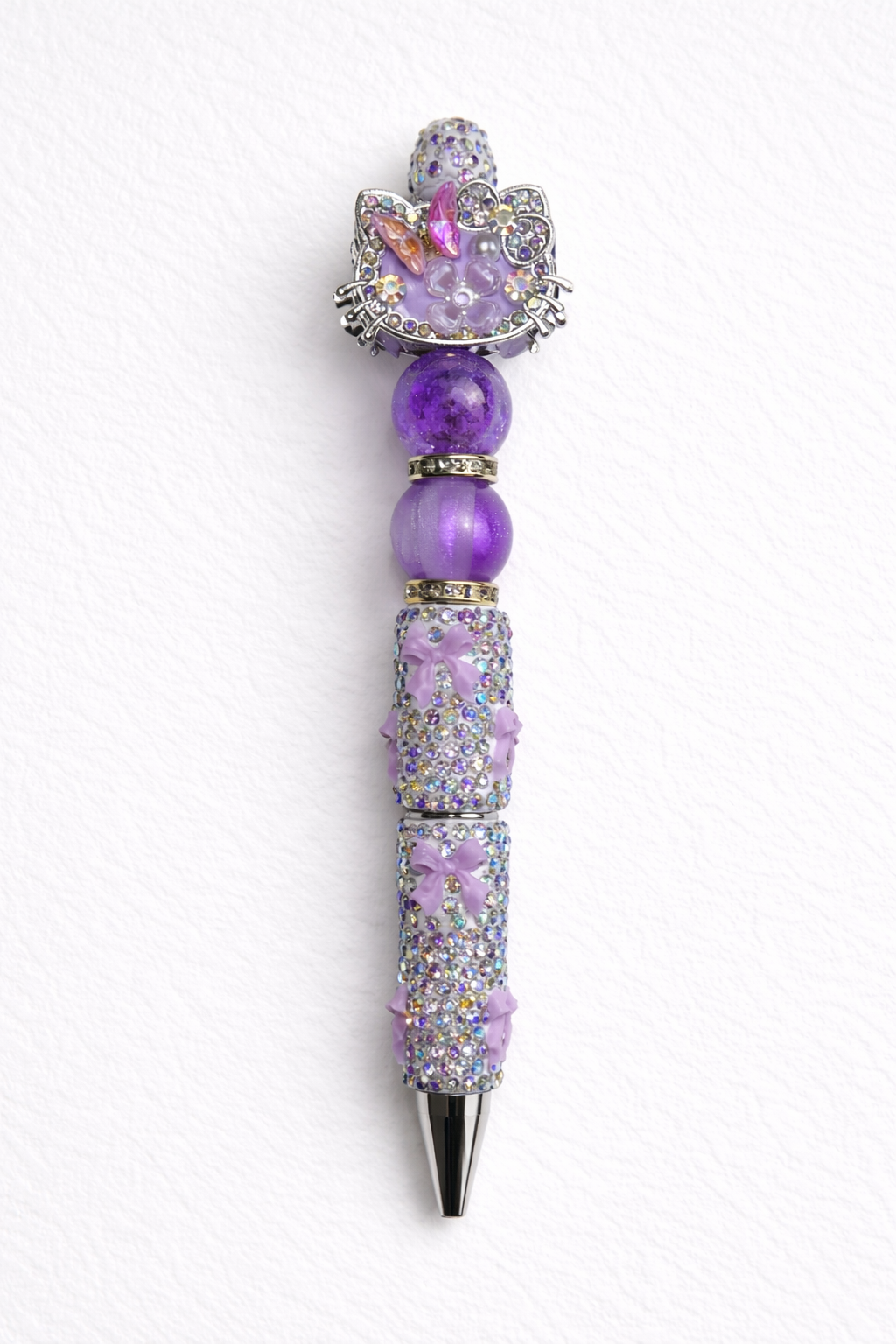 Lavender decorative kitty-cat pen with gemstone-like beads on a white cardstock background