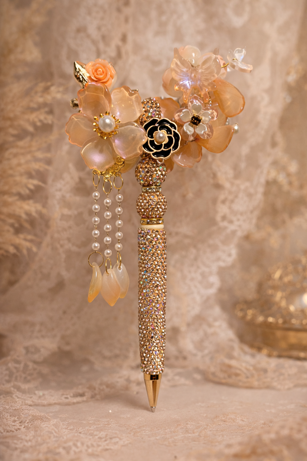 Decorative double-sided peach bling pen with large and small flowers, pearl embellishments, and gold accents on a lace-textured background