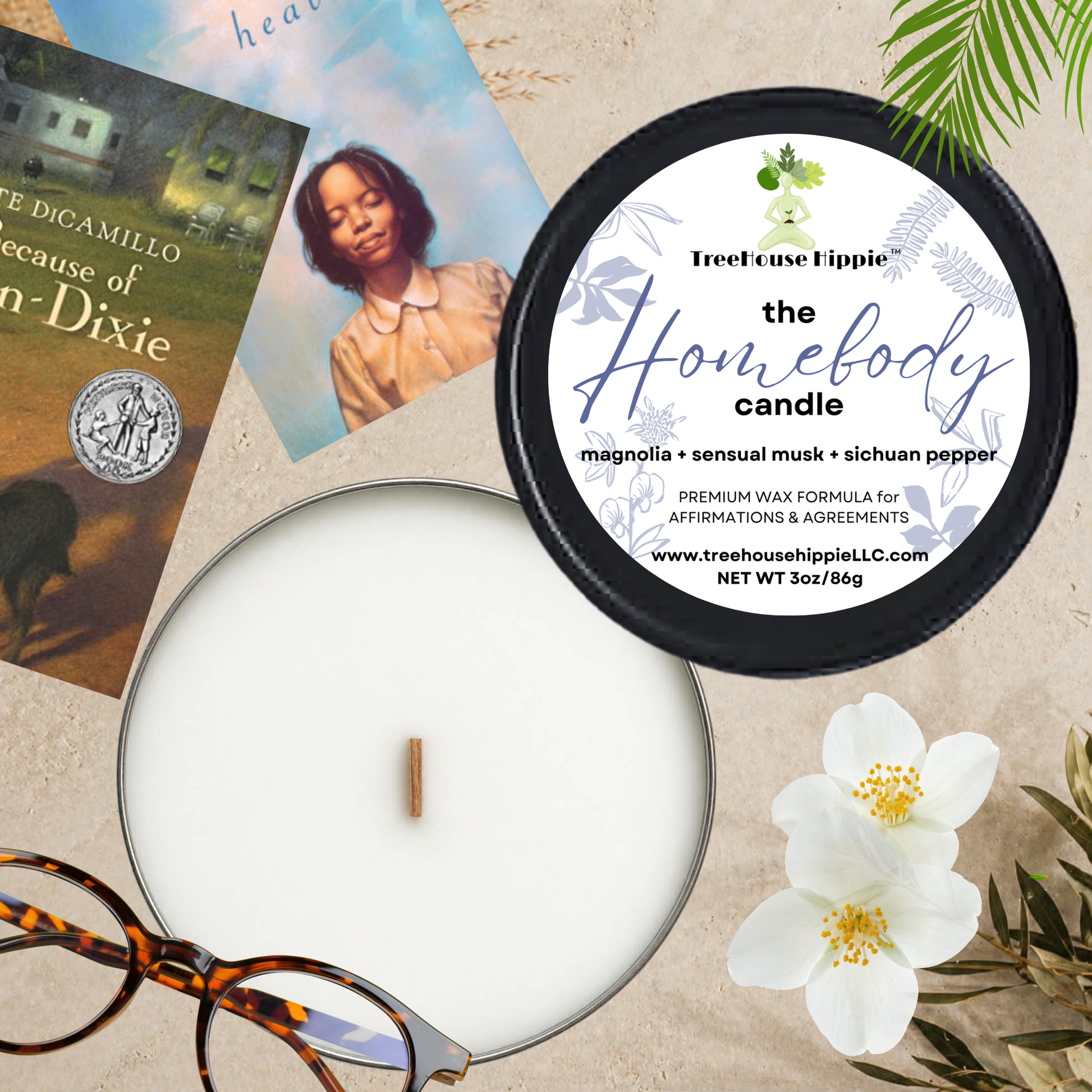 TreeHouse Hippie White Wax Travel-Size Candle in a Black Tin with Books, Glasses, & Flowers on a Textured Surface.