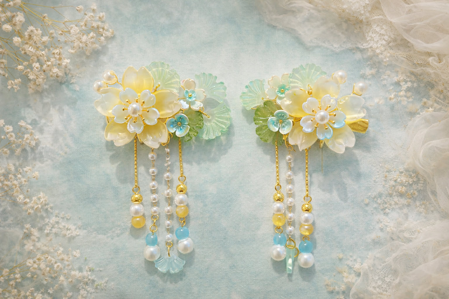 Yellow flower hair clips with pearl beaded accents on a soft mint-green background with white floral decor. 