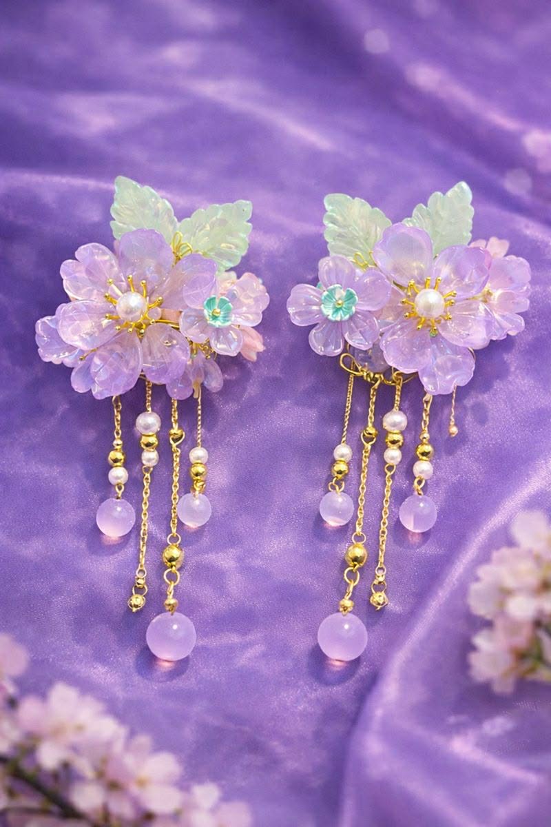 Lavender floral hair clips with beaded accents on a sheer purple fabric background